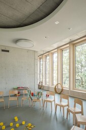 Vue intérieure : façade en bois. Au-dessus se trouve le plafond en béton